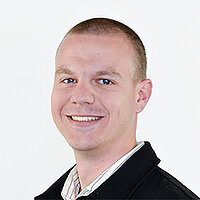 Florian Frey (Foto: BVS/Kerstin Müller) Junger Mann mit ganz kurzen Haaren und einem hellem Hemd und dunkelblauer Jacke lächelt.