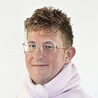 Patrick Laskowski (Foto: BVS/Phillip Guelland) Ein junger Mann mit einer runden Brille mit einer weißen Umrandung in Form einer 8, trägt einen rosafarbenen Schal um den Hals. Er hat strubbelige dunkelblonde Haare.