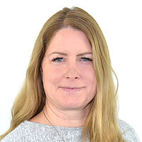 Claudia Croos Man sieht eine lächelnde Frau mit lagen blonden Haaren. Sie trägt einen hellgrauen Pullover.