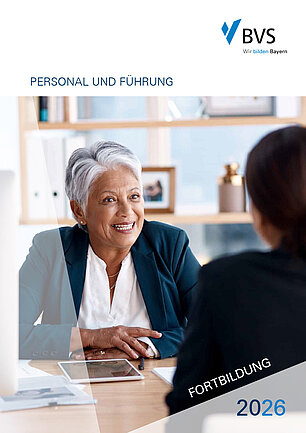 BVS Fortbildung 2026 - Cover Personal und Führung Eine Frau mit kurzen grauen Haaren ist im Gespräch mit einer Person, die man angeschnitten nur von hinten sieht. Vor sich auf dem Tisch liegt ein Tablet. Dahinter sieht man ein Regal mit Ordnern.
