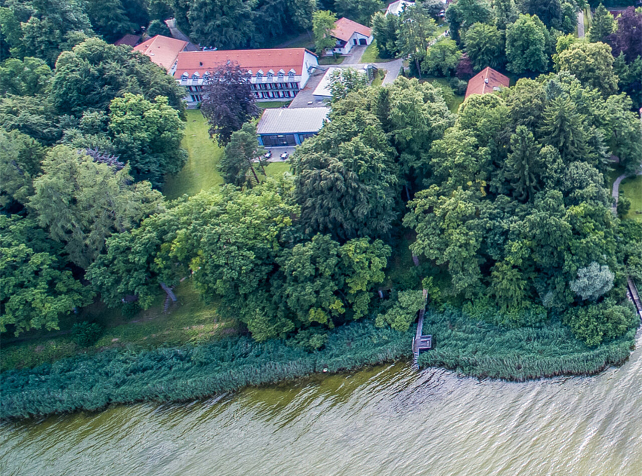 Auf dem Foto aus der Vogelperspektive sieht man die vielen unterschiedlichen Gebäude des BVS-Bildungszentrum Holzhausen mit vielen grün belaubten Bäumen.