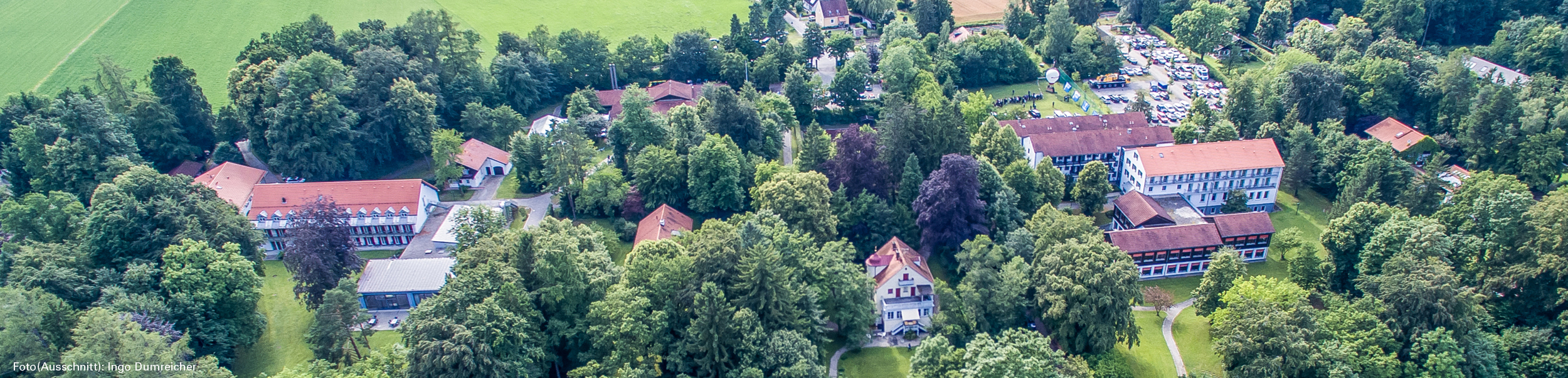 Auf dem Foto aus der Vogelperspektrive sieht man die vielen unterschiedlichen Gebäude des BVS-Bildungszentrum Holzhausen mit vielen grün belaubten Bäumen.